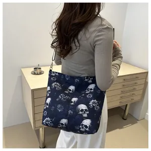 Detail of navy gothic tote bag with white skull print and floral patterns for women