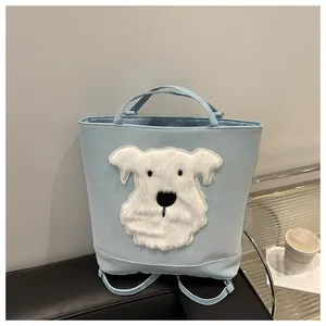 Detail of light blue multifunctional tote with a fuzzy white dog patch on a sofa