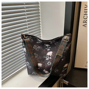 Close-up of vintage skull and red floral pattern on large tote bag with wide strap