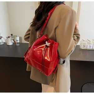 Detailed view of red glossy bucket bag with silver butterfly drawstring closure