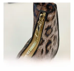 Gros plan du zip doré fluide sur un sac à main au motif léopard tendance pour femme