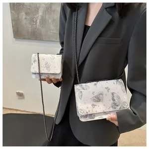 Comparaison de taille de sacs à chaîne blancs à motif papillon en grand et petit format