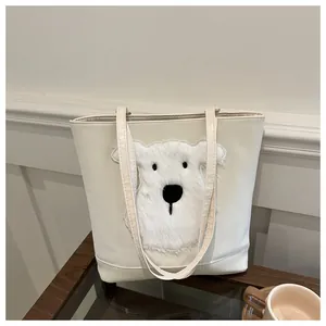 Detailed close-up of a cream tote bag with 3D plush puppy patch and leather texture