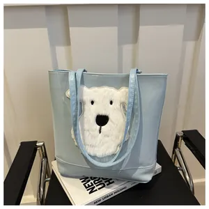 Close-up of a light blue tote bag with a white plush dog patch on a black chair