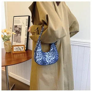 Sac hobo imprimé léopard bleu en forme de croissant porté par un mannequin chez soi