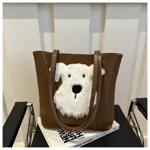 Detail of brown tote bag featuring a fluffy white plush dog patch and glossy leather finish