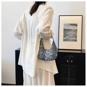 Détail du sac hobo à motif léopard gris avec poignée réglable porté par un mannequin