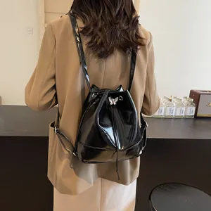 Black glossy pleated bucket backpack with cat ears and silver butterfly buckle on a model