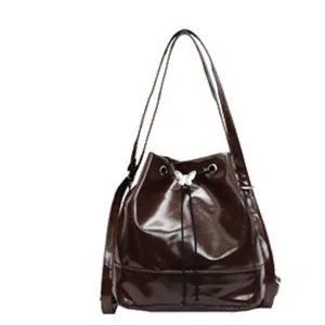 Dark brown pleated bucket bag with shiny patent leather finish and silver butterfly buckle