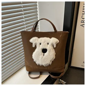 Detail of dark brown tote bag featuring a white plush dog patch and dual carrying straps