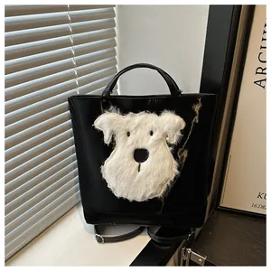 Detail showing the plush dog patch on a black convertible tote and backpack hybrid