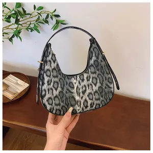 Détail du sac croissant à motif léopard avec poignée ronde et boucles dorées