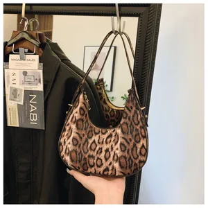 Détail du sac hobo léopard tendance avec fermeture éclair dorée et forme en demi-lune