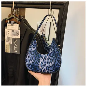 Détail du sac hobo léopard bleu avec fermeture éclair dorée et design en demi-lune chic