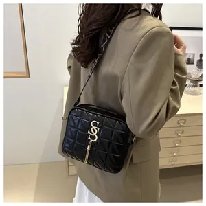 Quilted black crossbody bag with gold tassel detail and jacquard strap shown on model