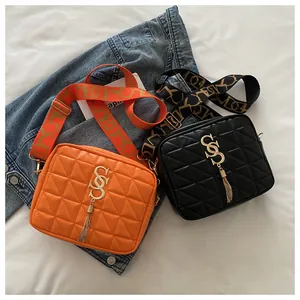Detail of quilted crossbody bags with gold hardware and geometric woven shoulder straps