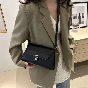Sac à bandoulière en cuir noir avec boucle dorée et bandoulière élégante de style