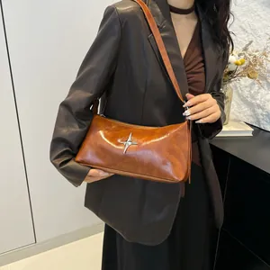 Brown leather shoulder bag with silver star ornament and sleek Y2K minimalist design