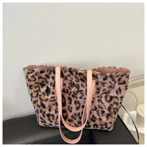 Close-up of pink leopard plush tote bag with soft faux fur texture and leather handles