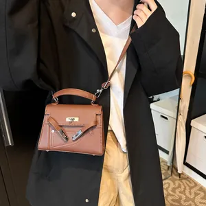 Brown litchi pattern leather Kelly handbag with adjustable crossbody strap on model