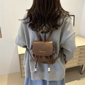 Brown leather backpack with retro plaid stitching and fashion lettering detail
