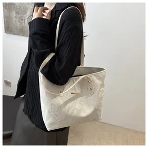 Close-up of marble texture tote bag with golden bar detail worn by a model