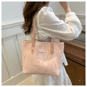 Detail of pink marble ripple tote bag showing shoulder strap and gold metal rivet accents