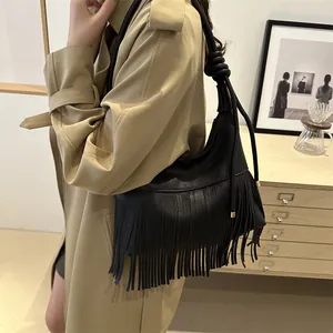 Minimalist black fringe shoulder bag with bohemian tassels and knotted strap detail
