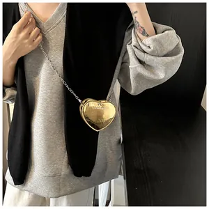 Detailed view of mini golden heart-shaped chain bag with embossed metallic leather texture