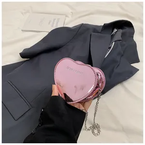 Detail of pink metallic heart bag with chain strap and fashion logo text