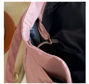 Detalle del cierre de cremallera metálica en el bolso tote de nailon rosa
