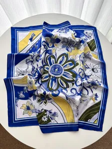 Detail eines Seidenschals mit abstrakten Blumenprints in Blau und Gelb auf Seidenimitat