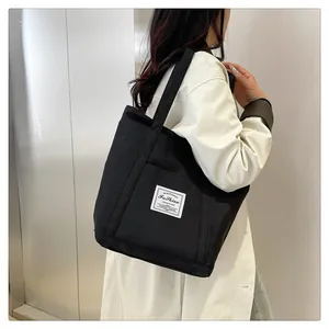 Bolso tote grande de nailon negro en una modelo, destacando el estilo casual y espacioso