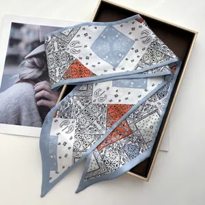 Detail of elegant faux silk narrow scarf with orange paisley and geometric patterns