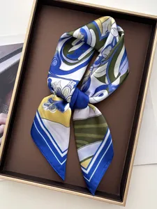 Nahaufnahme eines eleganten Seidenschals mit Blumendruck in einer braunen Geschenkbox