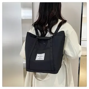 Detalle de mochila de nailon negro con etiqueta Fashion y correas reforzadas