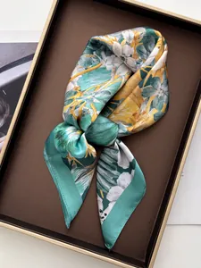 Detail view of floral silk scarf with hand-rolled edges on a display tray