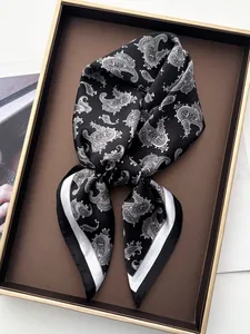 Detail of vintage paisley silk scarf with black and white patterns on a luxury tray