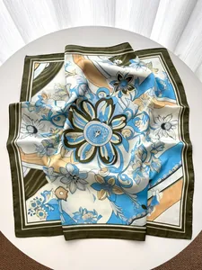 Detailansicht eines Seidenschals mit Blumenmuster und blau-grünen abstrakten Motiven