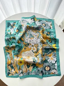 Detail of elegant floral silk-like scarf with rose prints and green hand-rolled edges