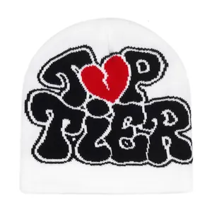 Detailansicht der weißen Strickmütze mit schwarzem TIER-Schriftzug und rotem Herzmotiv