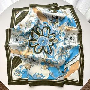 Detail eines Seidenschals mit Blumenprint, elegantem Vintage-Muster und olivgrünem Rand