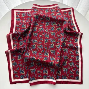 Detail of red paisley square scarf with satin texture and intricate geometric border patterns