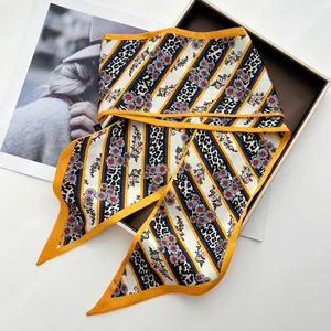 Detail of silk-like twilly scarf with leopard print and floral patterns on magazines