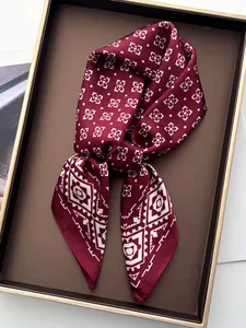 Close-up of burgundy silk scarf featuring vintage white geometric patterns and smooth texture