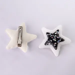 Dettaglio di fermagli per capelli a stella in peluche bianco e nero con glitter e clip metalliche