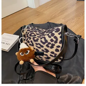 Dettaglio borsa a tracolla leopardata con ciondolo di peluche e logo fashion