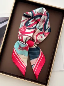 Detailansicht eines bunten Seidenschals mit Rollsaum auf einem edlen Tablett