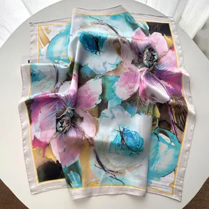 Close-up of abstract oil painting floral silk scarf with elegant folds on white table