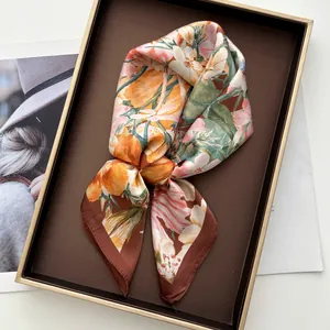 Close-up of elegant floral silk scarf with orange tulips in a brown gift box